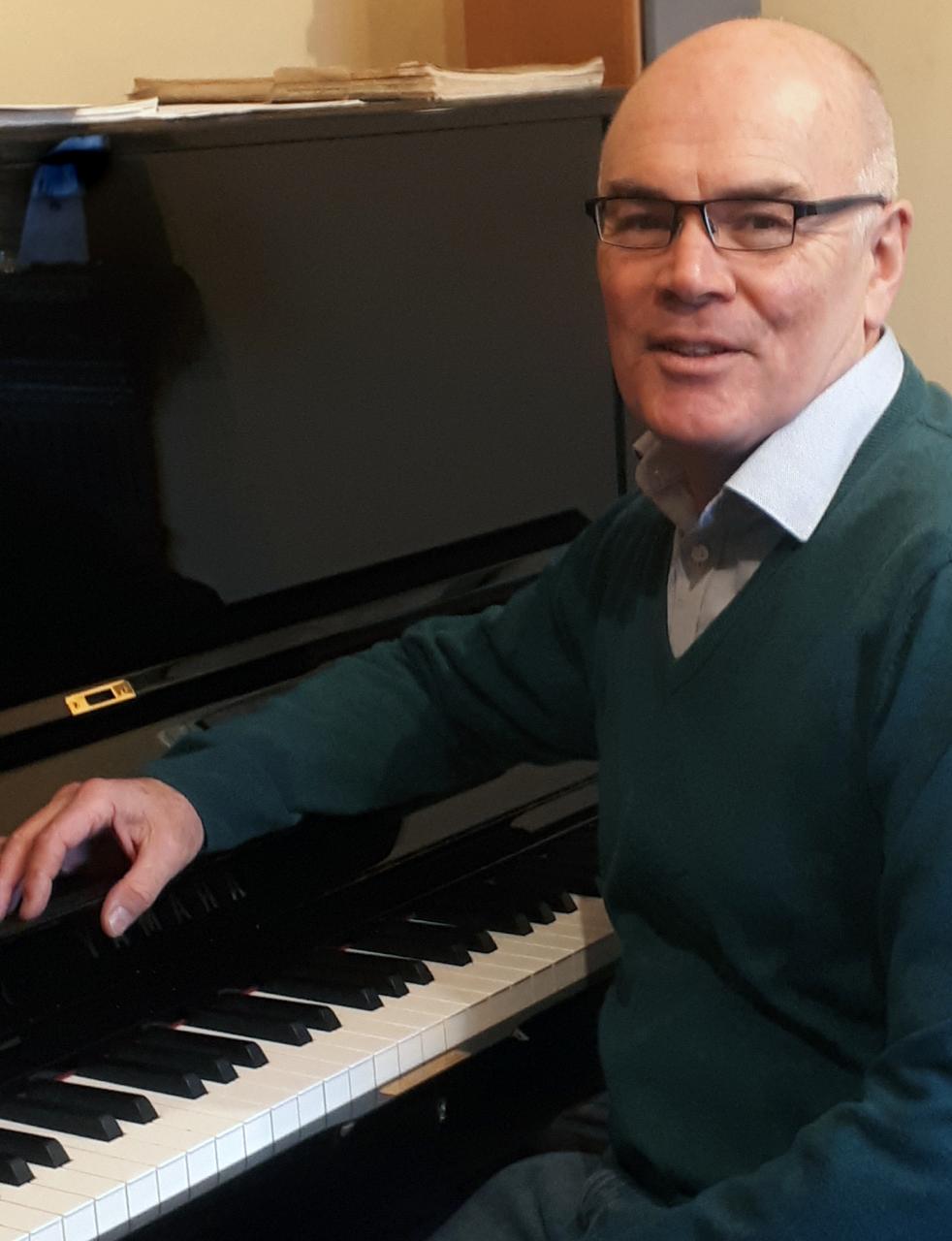 Paul Roberts sitting at his piano